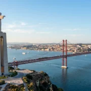 The Cristo Rei statue in Almada above the Tagus with the 25 de Abril Bridge and Lisbon behind