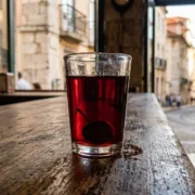 A glass of deep-red ginjinha with a soaked cherry on a Lisbon bar counter