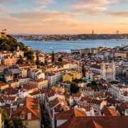 Golden-hour view over Lisbon's rooftops, castle and the Tagus river