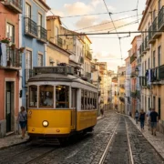 A yellow Tram 28 climbing a narrow cobbled street in Alfama, Lisbon